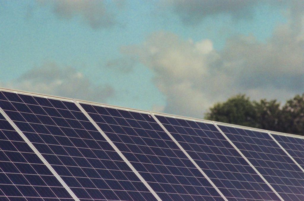 Photograph of solar panels capturing renewable energy under a blue sky, promoting sustainability and environmental protection.